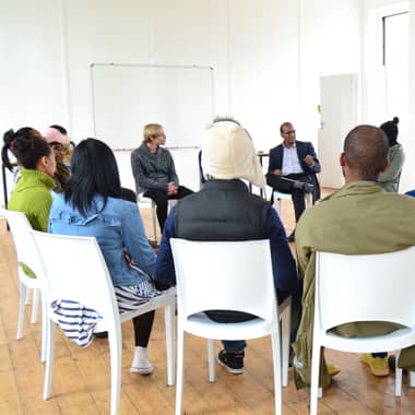 Room of people sitting in a circle.